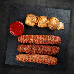 Assorted delicious grilled meat on a stone board. Top view