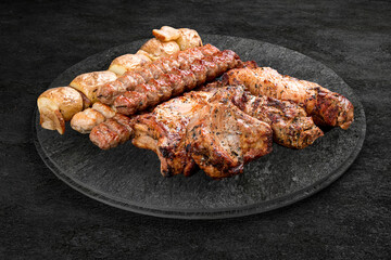 A selection of grilled gourmet meats on a rustic stone board.  Assorted meat