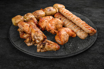 A selection of grilled gourmet meats on a rustic stone board. Assorted meat