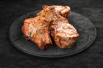 A selection of grilled gourmet meats on a rustic stone board. Pork kebab