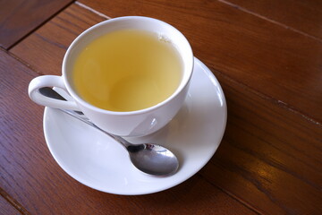 A cup of green tea on a wooden background.
