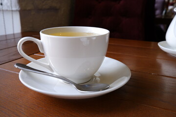 A cup of green tea on a wooden background.