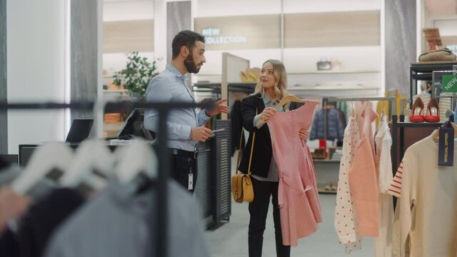 Beautiful Female Customer Shopping in Clothing Store, Retail Sales Associate Talks with Client. Diverse People in Fashionable Shop, Choosing Stylish Clothes, Colorful Brand with Sustainable Designs