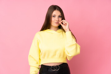 Teenager caucasian girl isolated on pink background showing a sign of silence gesture