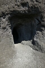 Höhleneingang im schwarzen Basaltfelsen in Ettringen / Eifel
