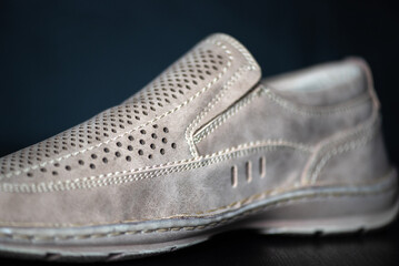 Men's summer leather shoes on a dark background, close-up.