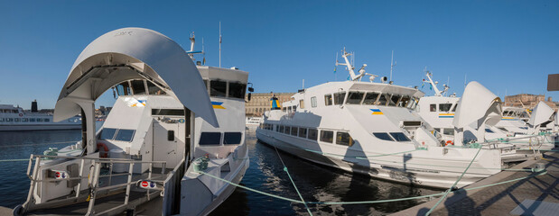 Morning view over a pier with commuting boats lined up before leaving for the Stockholm archipelago