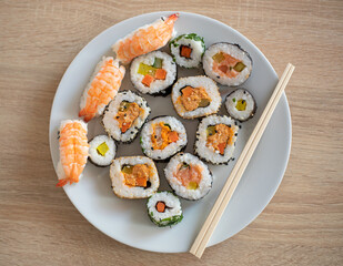 Closeup on sushi set of maki with chopsticks on a white plate