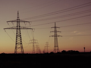 Fototapeta na wymiar Strommasten und Energieleitungen in der Abenddämmerung