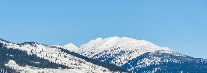 panorama of mountains with snow on top clear blue sky British Columbia Canada