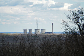 Fototapeta na wymiar Smoking power plant in Visonta, Hungary. Color photo illustration of environmental pollution, energy industry or greenhouse gas emission.