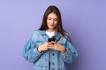 Teenager caucasian girl isolated on purple background sending a message with the mobile