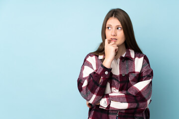 Teenager caucasian girl isolated on blue background nervous and scared