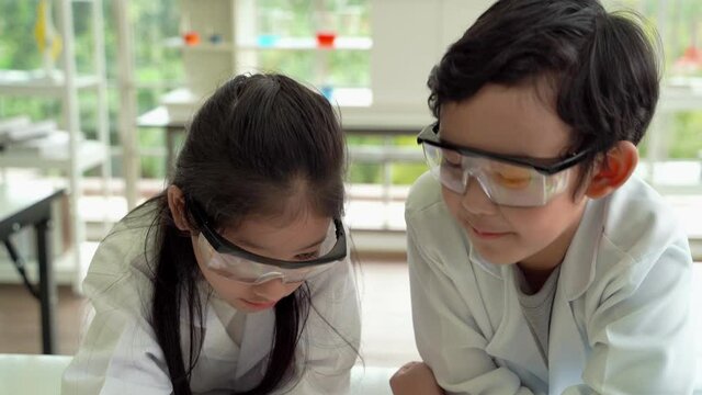 children who are studying science in the classroom make a cheeky face.
