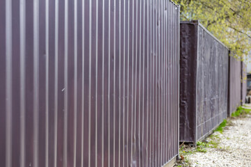 Old 40-foot shipping containers are abandoned and lined up in a street dump during the day