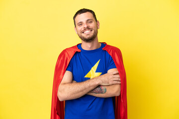 Super Hero Brazilian man isolated on yellow background keeping the arms crossed in frontal position © luismolinero