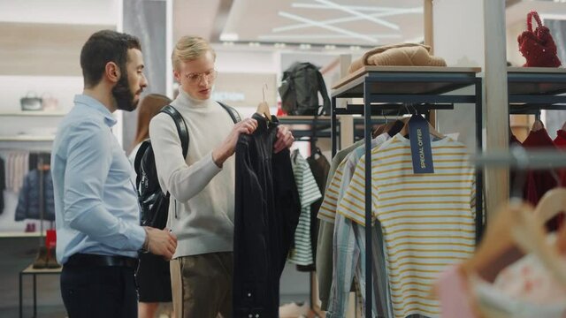 Handsome Male Customer Shopping in Clothing Store, Retail Sales Assitant Helps with Advice. Diverse People in Fashionable Shop, Choosing Stylish Clothes, Colorful Brand with Sustainable Designs