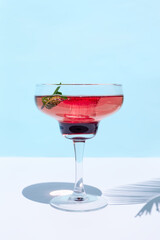 Fresh summer strawberry cocktail or mocktail on blue patel background. Creative drink beverage on sunlight with shadows