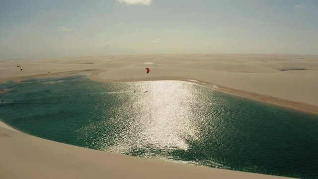 Lencois Maranhenses kitesurfer lagoon dunes paradise desert water sports aerial view panorama drone 4k Brazil