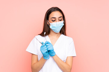 Woman dentist holding tools isolated on pink background