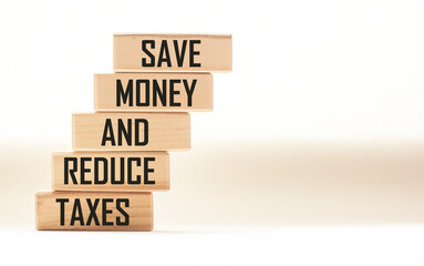 SAVE MONEY AND REDUCE TAXES text on wooden blocks and white background. Smart - Saving money and tax cuts acronym in business concept,