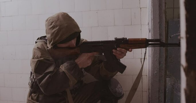 The terrorist shoots from the AK-47 automatic machine. Concept: terrorist attack, study, army.