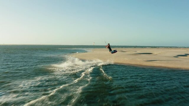 kitesurfer jumping over beach aerial drone following water sports travel tourism summer brazil atins 4k