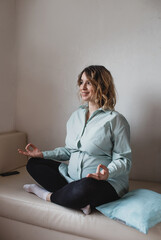 Young beautiful pregnant woman is doing yoga in quarantine at home. Poses relaxation, calm down, relax.