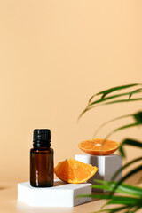 Amber glass bottle with essential oil and citrus orange fruits on geometric podium