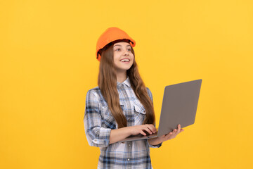 happy teen girl in helmet and checkered shirt using laptop, school