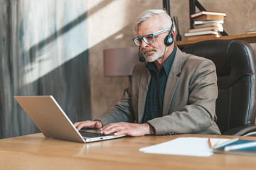 Online webinar. The senior teacher is giving a lesson at a laptop. Remote education and work.