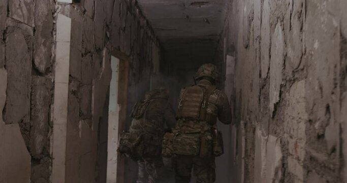 Two soldiers move along the corridor in search of terrorists, one of them steps on a mine and it explodes, gets contusion and severe burns. Concept: Anti-terrorist mission, terrorist attack, military.