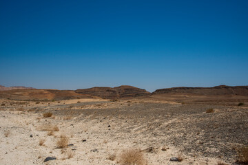 Fototapeta na wymiar A view from the crater in the Ramon Crater. Arid desert view. White sands and a horizon of blue skies. Negev, Israel. High quality photo