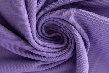 soft knitted fabric for sewing clothes in lilac color, coiled