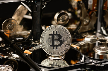 Bitcoin on the background of hard drives, the concept of mining cryptocurrencies using hard and SSD drives.