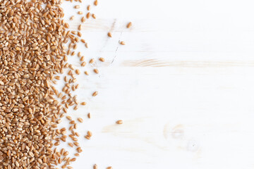 border of wheat grain seeds on white wood