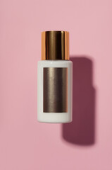 white cream tube with gold cap isolated on pink blurred background, cosmetics mock up, skin care, body lotion