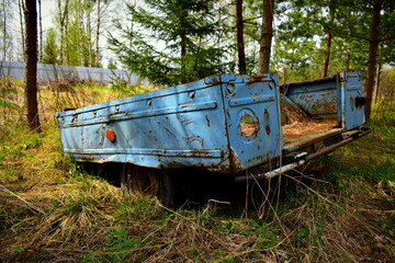 Old trailer overgrown with grass