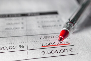 Invoice with a red pen on the tabel, close up