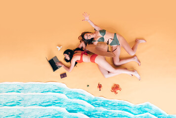 top view of female remote workers at the beach. Travel bloggers and digital nomads with notebook at the sea. women on sabbaticals working remotely. studio shoot on yellow background.