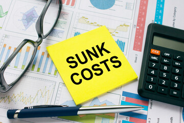 Sticker with text Sunk Costs with, glasses, pen and calculator