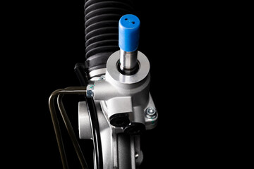 Obraz premium Studio lighting. on a black background, the steering rack of the car. New part.