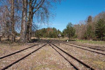Fototapeta premium Crossing railway tracks in the forest. Hel, Pomeranian district, Poland. Selective focus. 