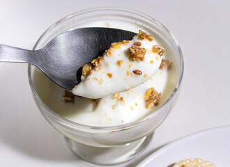 Full Spoon of homemade oatmeal granola and yogurt in a bowl.  Healthy food. Concept of diet. Selective focus