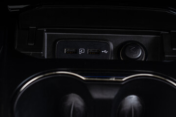 Fototapeta premium Opened car USB port in the car for connecting device. Power output of usb charger close up view. Car interior.