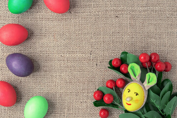 Yellow egg in the shape of an Easter bunny and multicolored eggs.