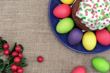 Obraz na płótnie Canvas Plate with colorful Easter eggs, Easter cake and red berries.