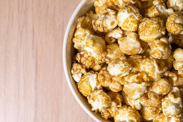 a cup of popcorn on a wooden background . place for the label