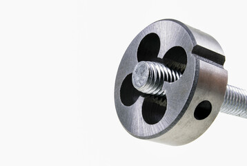 Die for cutting threads in a screw during operation. Mechanical accessories in a locksmith's workshop.