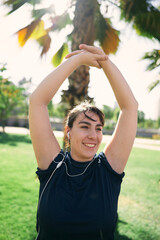 a beautiful white woman with brown hair exercises her arms to be ready for physical activity                  